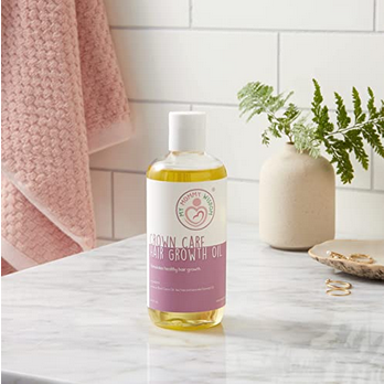 Bottle of My Mommy Wisdom Crown Care Hair Growth Oil on the bathroom counter