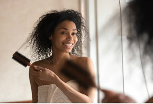 Black woman brushing out tangled hair